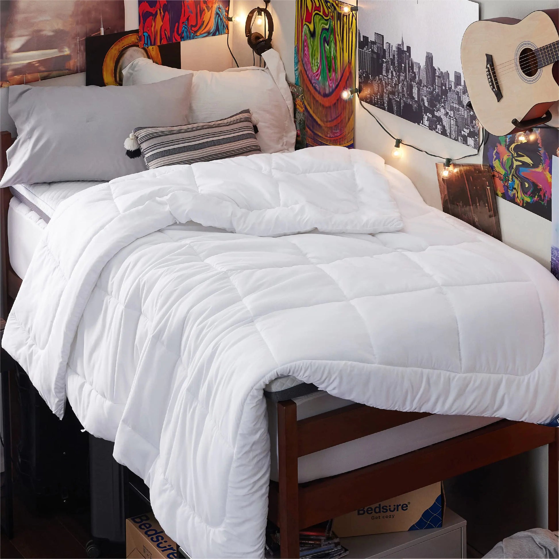 White twin XL comforter duvet insert on a cozy bed with gray pillows and colorful wall decorations