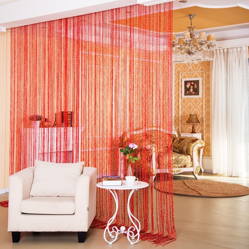 Shopi Vella red decorative thread door curtain hanging in a modern living room with white armchair and side table