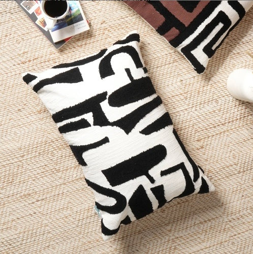 Shopi Vella handcrafted cotton tufted pillow case with black and white abstract design on beige rug