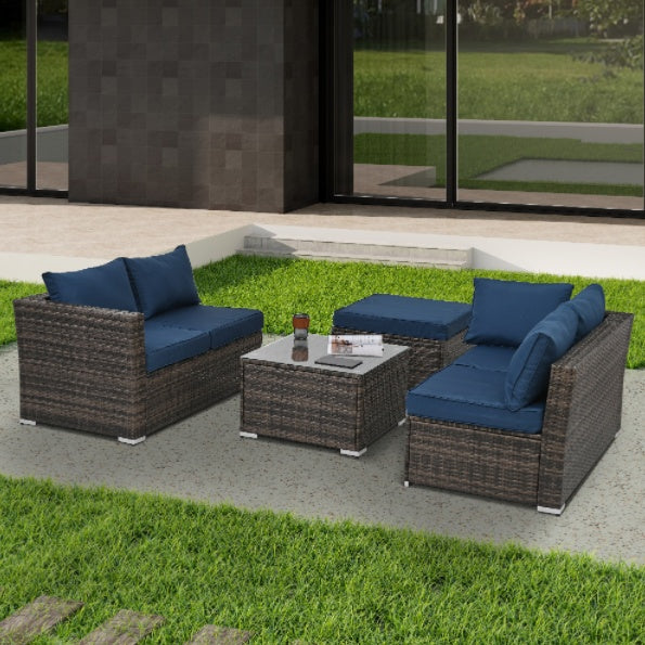 Shopi Vella outdoor wicker furniture with glass table featuring blue cushions on modern patio setup