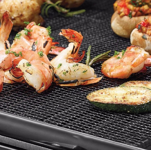 Grilled shrimp and vegetables cooking on a nonstick bakeware set grill pan for easy cleanup