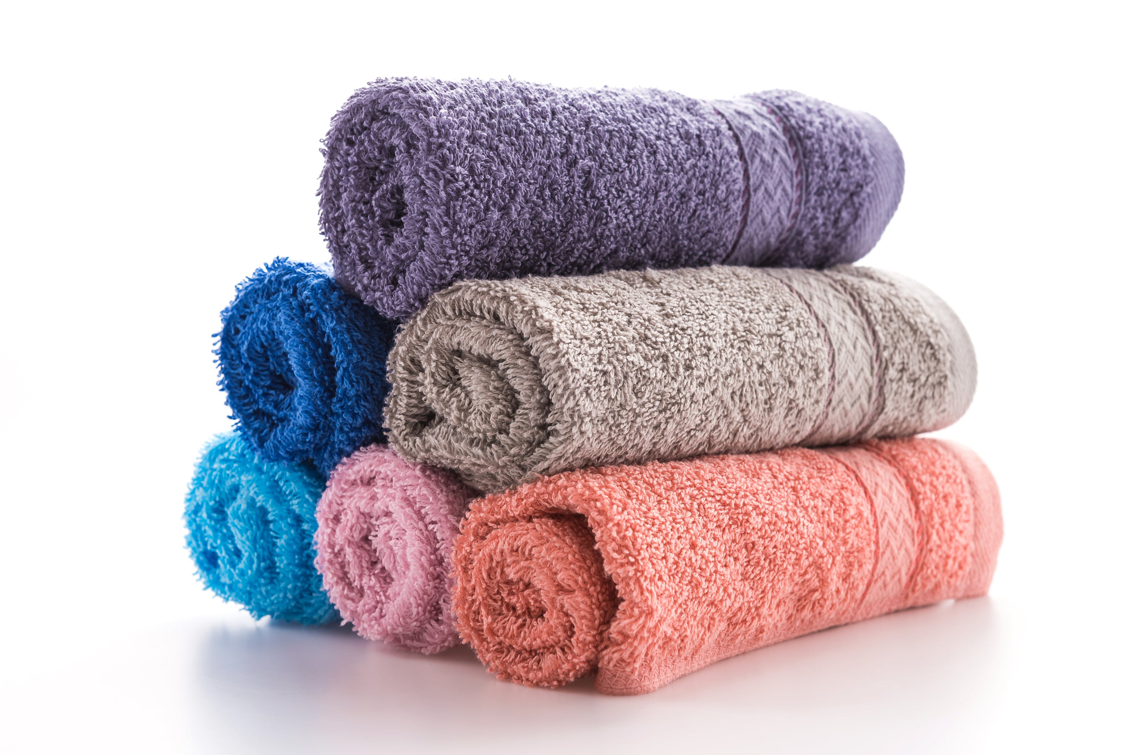 Stack of colorful luxury bath towels made from soft absorbent cotton for bathroom and travel use