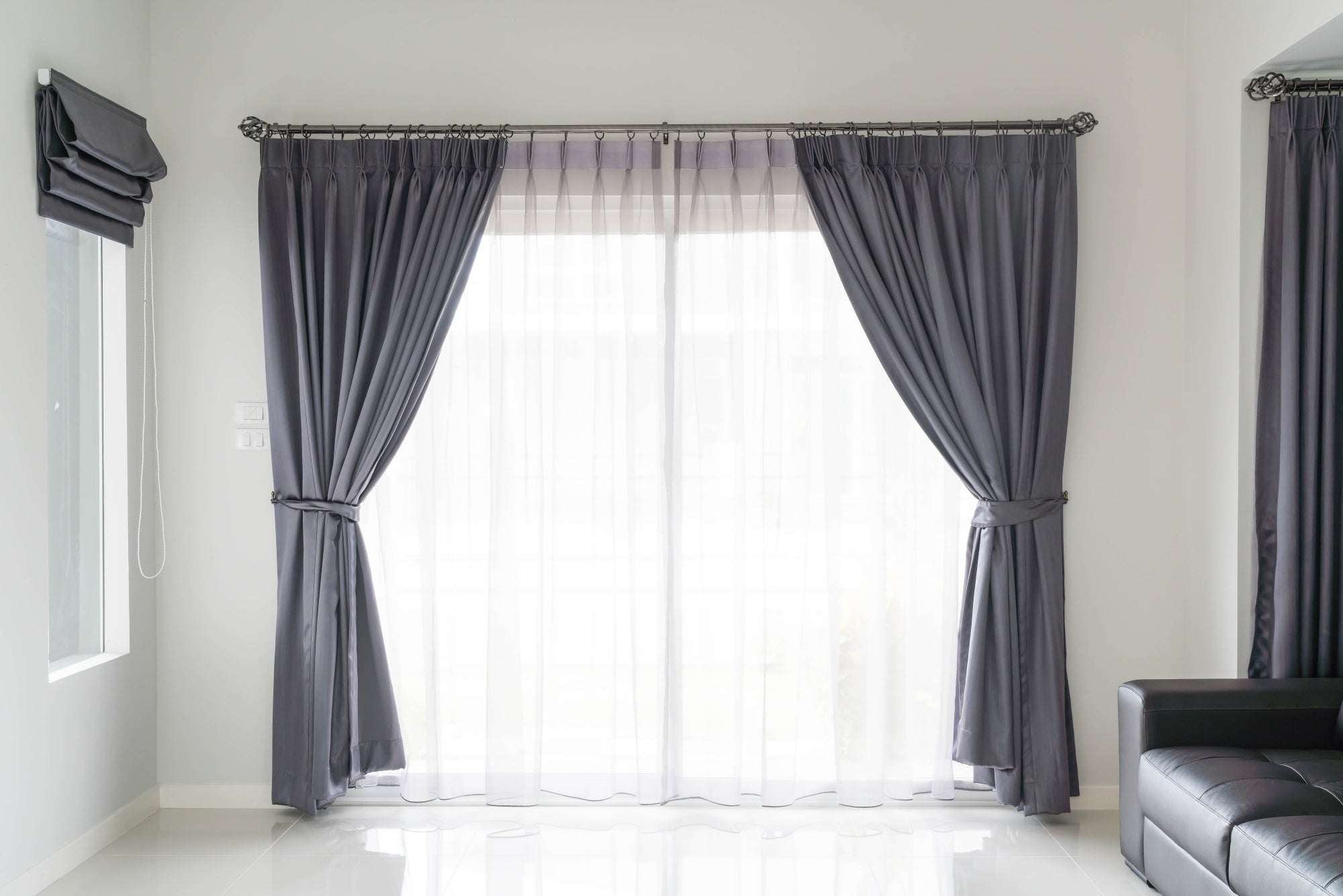 Elegant modern blackout curtains in dark gray paired with sheer white curtains in a bright living room