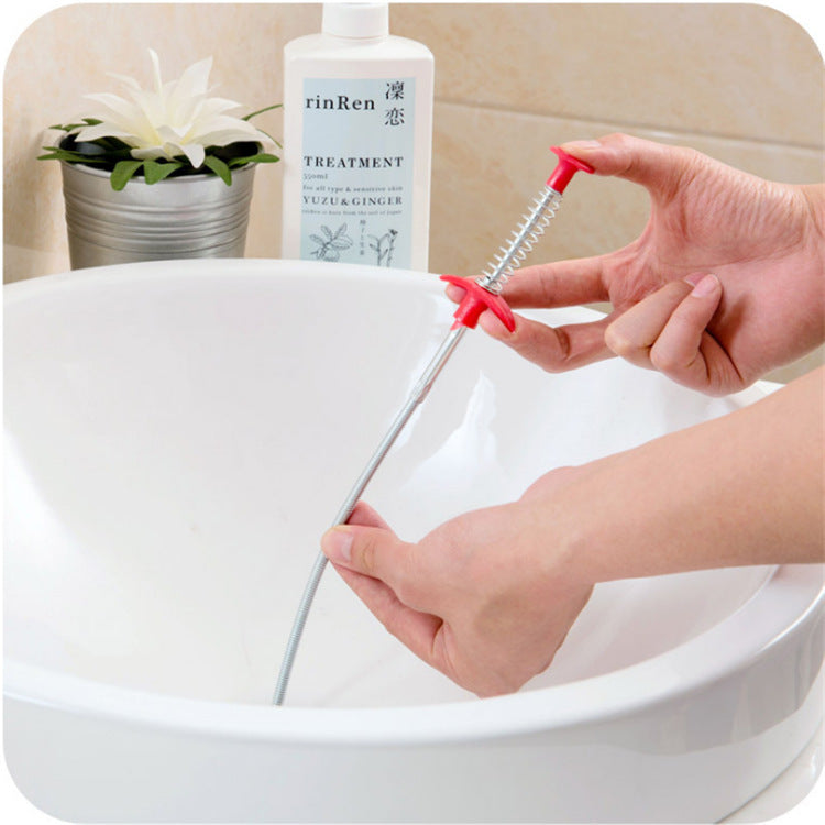 60cm hair cleaner for kitchen sink being used to clear drain with hands and red handle