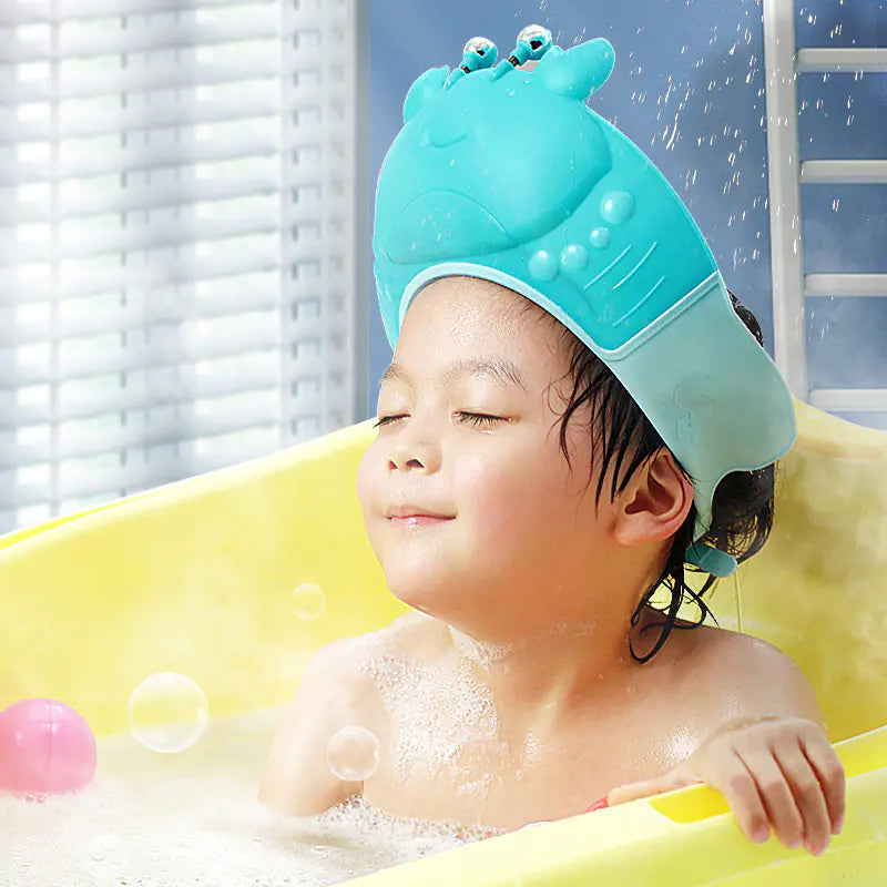 Toddler wearing an adjustable baby shower cap in a yellow bathtub with water splashing
