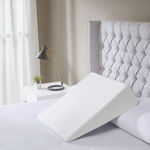 Shopi Vella adjustable back support pillow on a bed with a tufted gray headboard in a bright bedroom