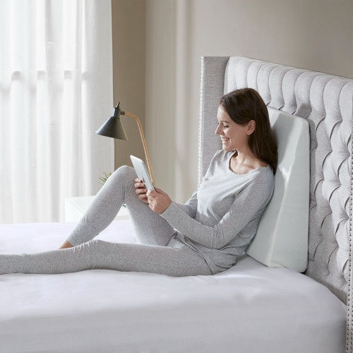 Woman sitting on bed using an adjustable back support pillow from Shopi Vella bedding set