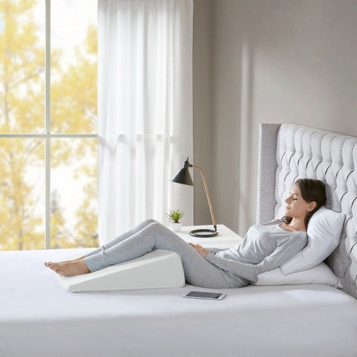 Woman lying on bed using adjustable back support pillow from Shopi Vella bedding set in a bright bedroom