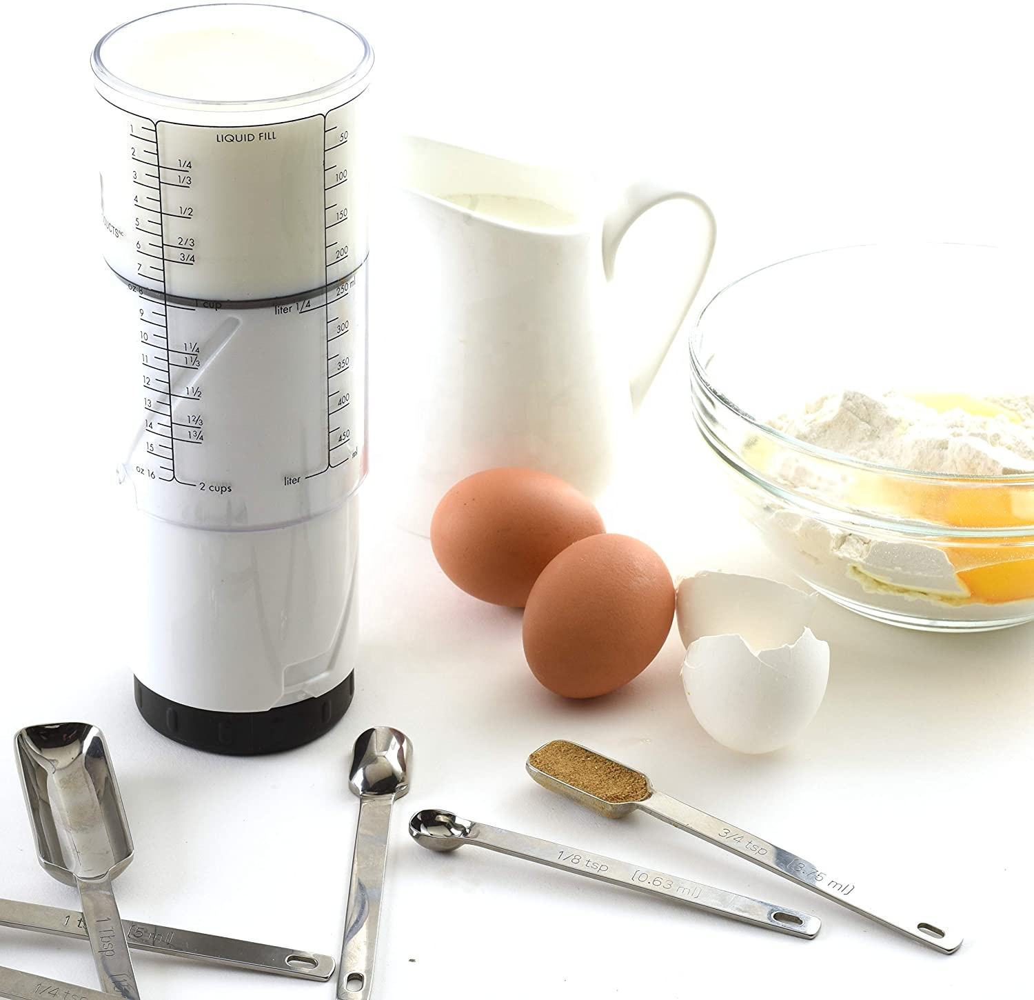 Shopi Vella adjustable rotating measuring cup filled with flour next to eggs milk and measuring spoons