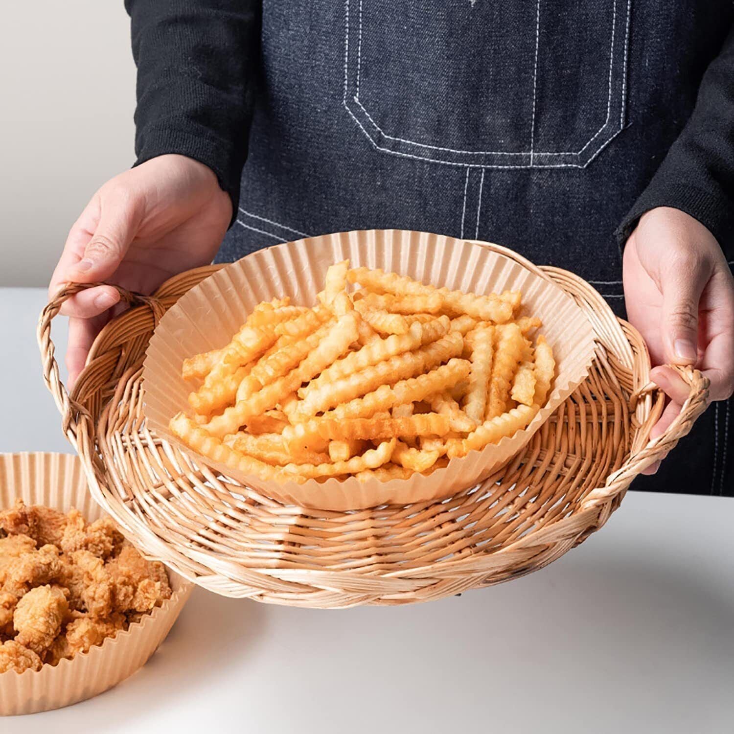 Shopi Vella air fryer disposable liners holding crispy crinkle fries on a wicker tray