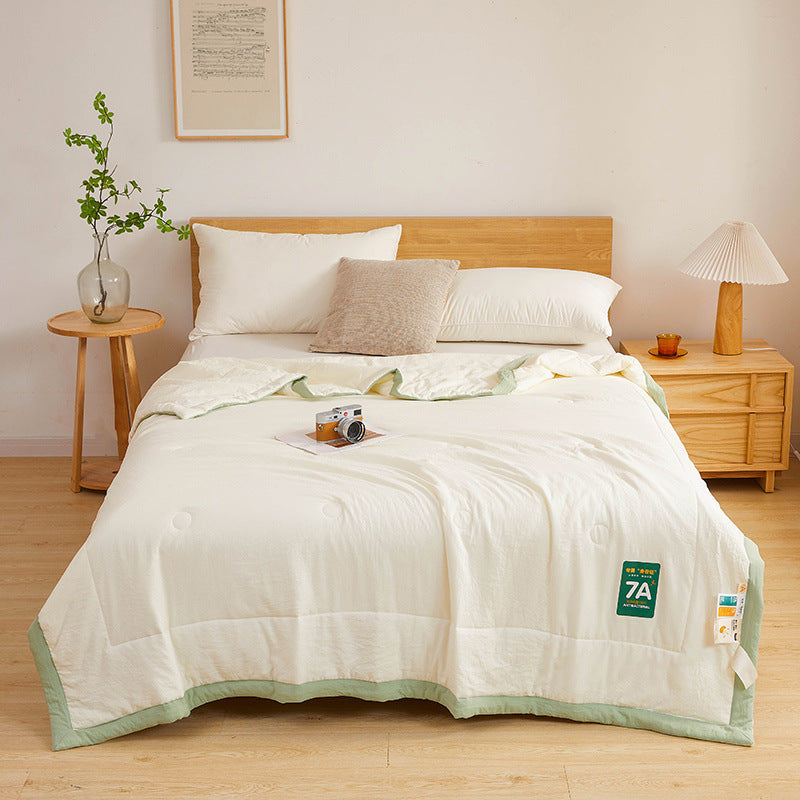 Shopi Vella antibacterial summer quilt with light green edge neatly spread on bed in cozy bedroom
