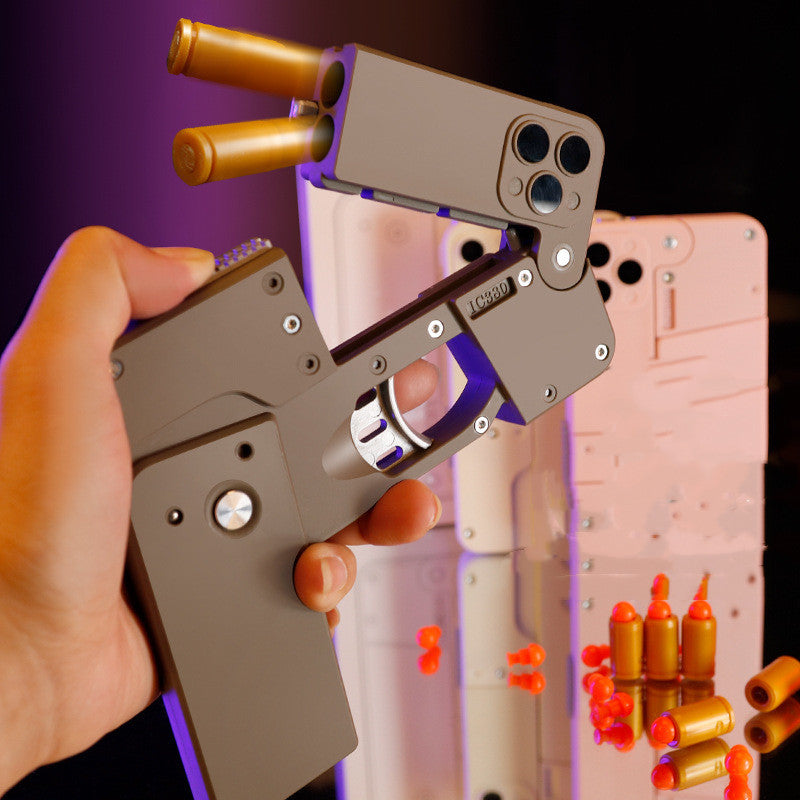 Hand holding Shopi Vella automatic shell throwing toy pistol with shell cartridges and orange projectiles