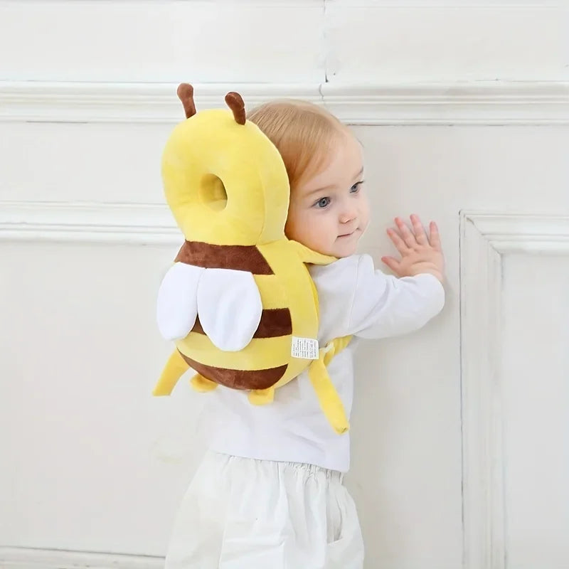 Baby wearing yellow bee-shaped baby head protection pillow to prevent head injuries while crawling