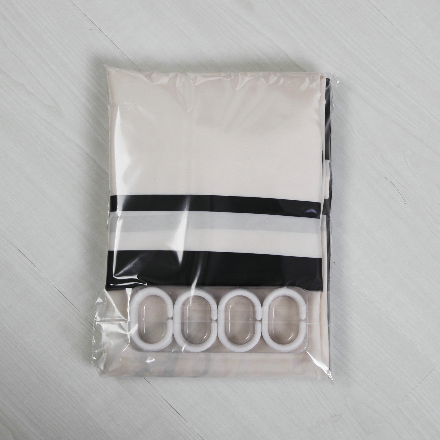 Shopi Vella waterproof shower curtain in black and white stripes with white hooks in clear packaging