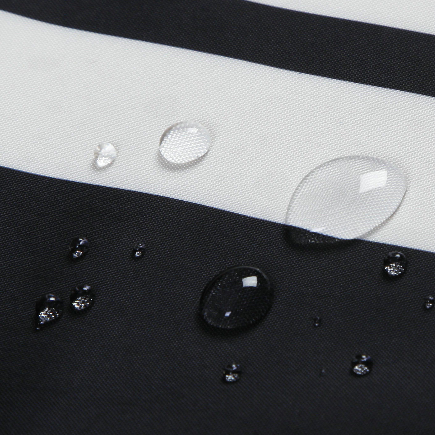 Close-up of waterproof shower curtain fabric with water droplets on black and white stripes