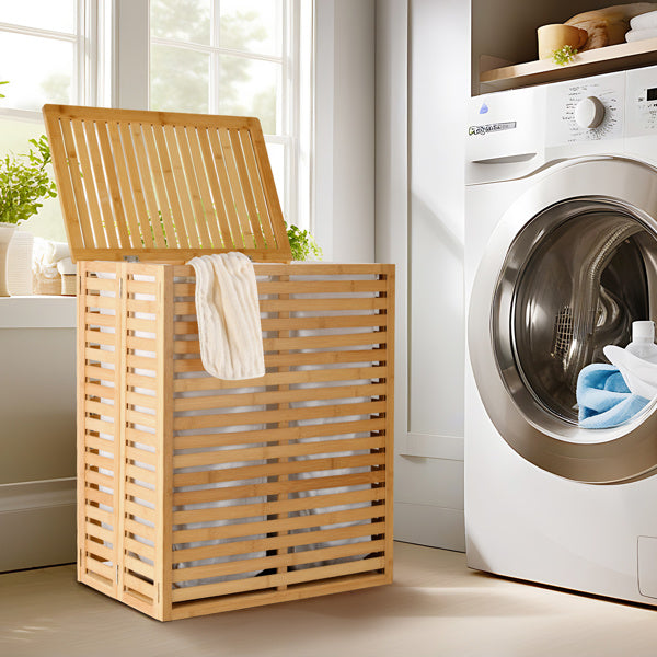 Shopi Vella bamboo laundry basket with lid standing next to a washing machine in a bright laundry room