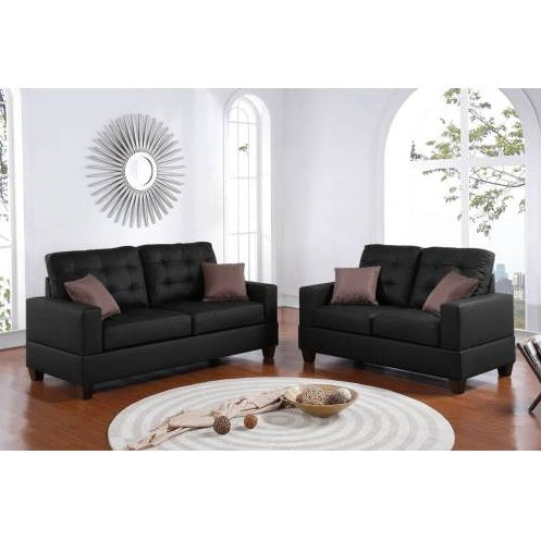 Shopi Vella black faux leather sofa set featuring two cushioned sofas with brown accent pillows in a bright living room