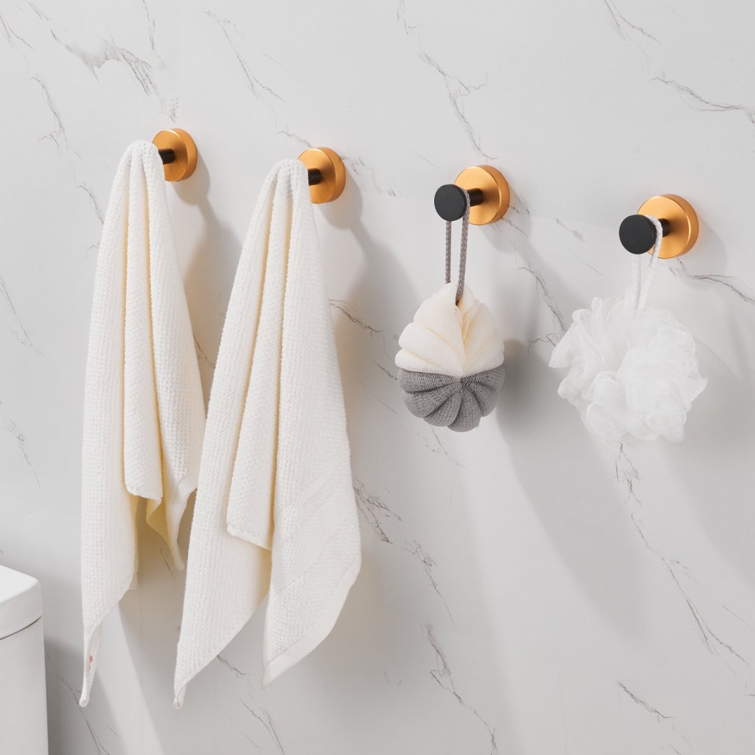 Shopi Vella black gold wall hooks set holding towels and bath sponges on marble bathroom wall