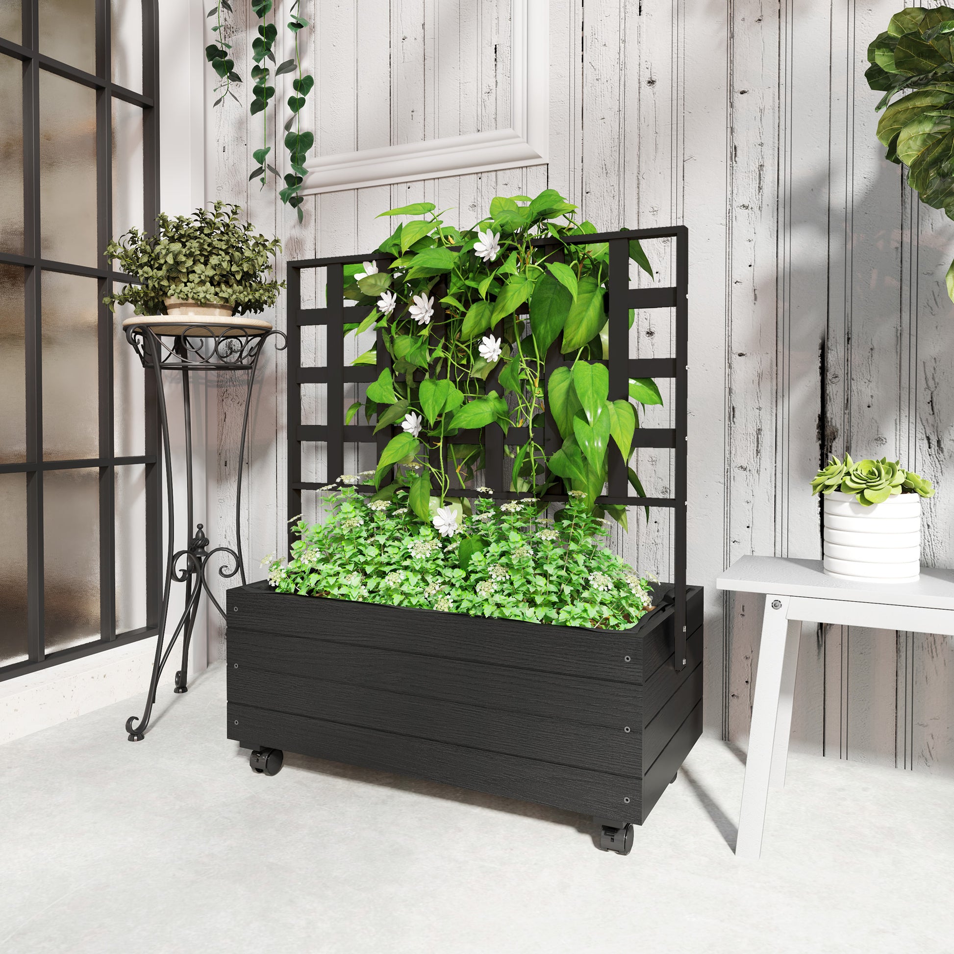 Shopi Vella black raised garden bed with trellis filled with green plants in a bright indoor space