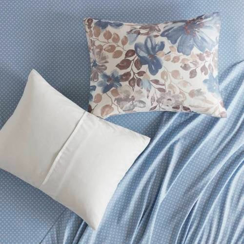 Blue floral comforter set queen by Shopi Vella with patterned and plain pillows on bed