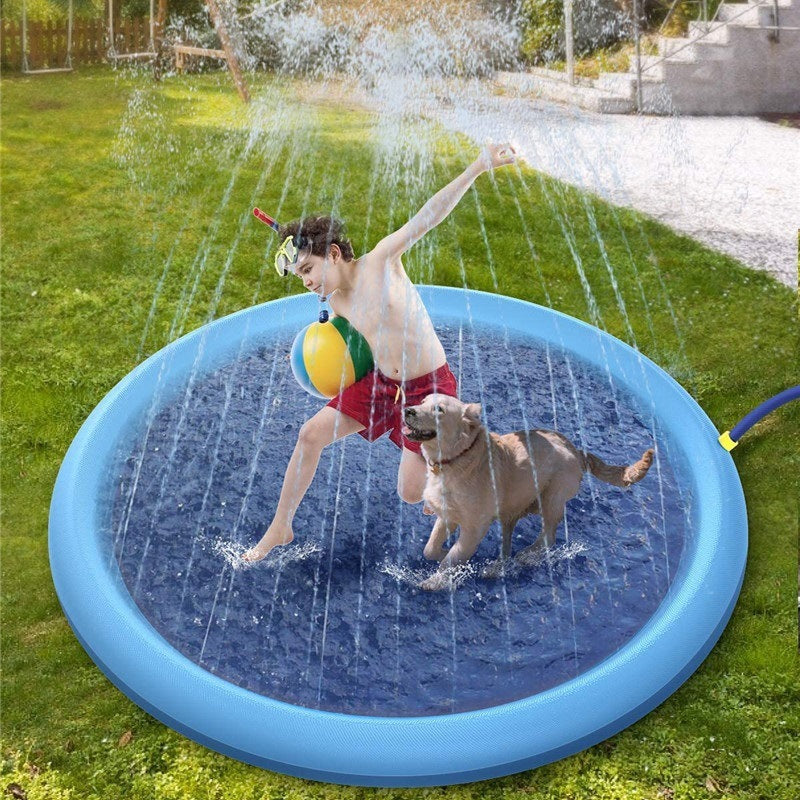 Boy and dog playing on a blue non-slip splash pad for kids outdoors on grass