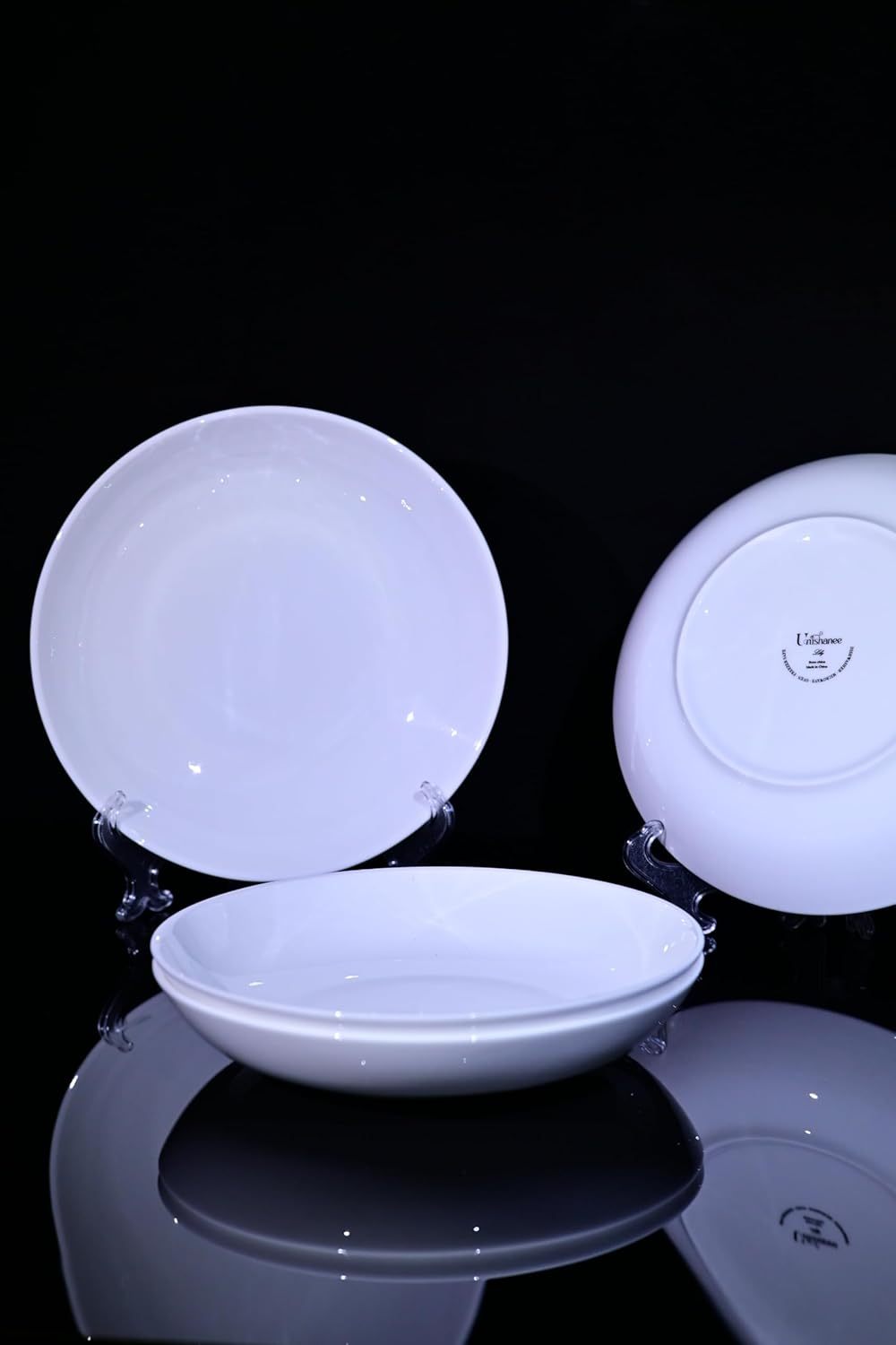 Shopi Vella bone china dinnerware set with white plates and bowls displayed on stands