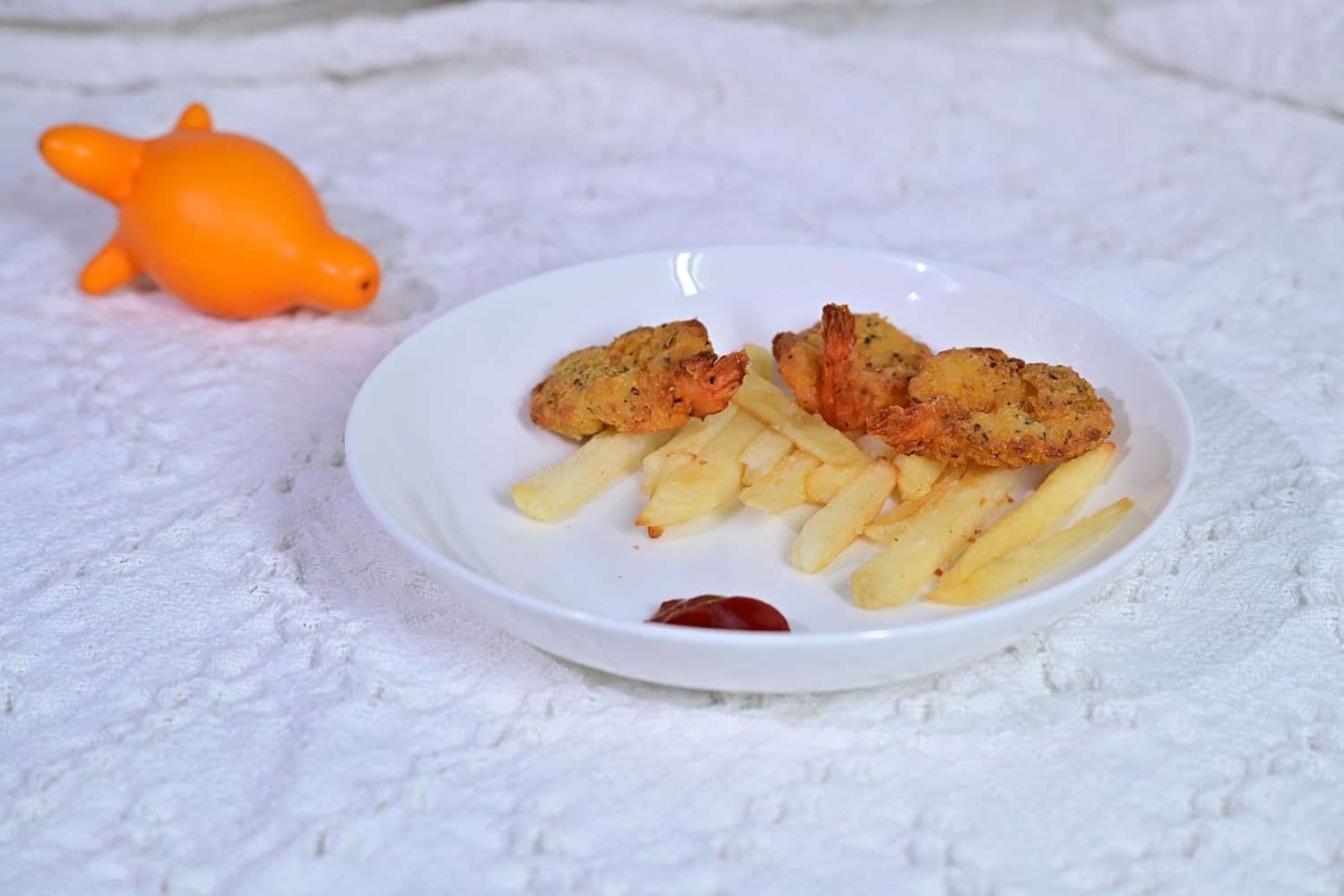 White bone china dinnerware set plate with fried chicken, French fries, and ketchup on a textured white surface