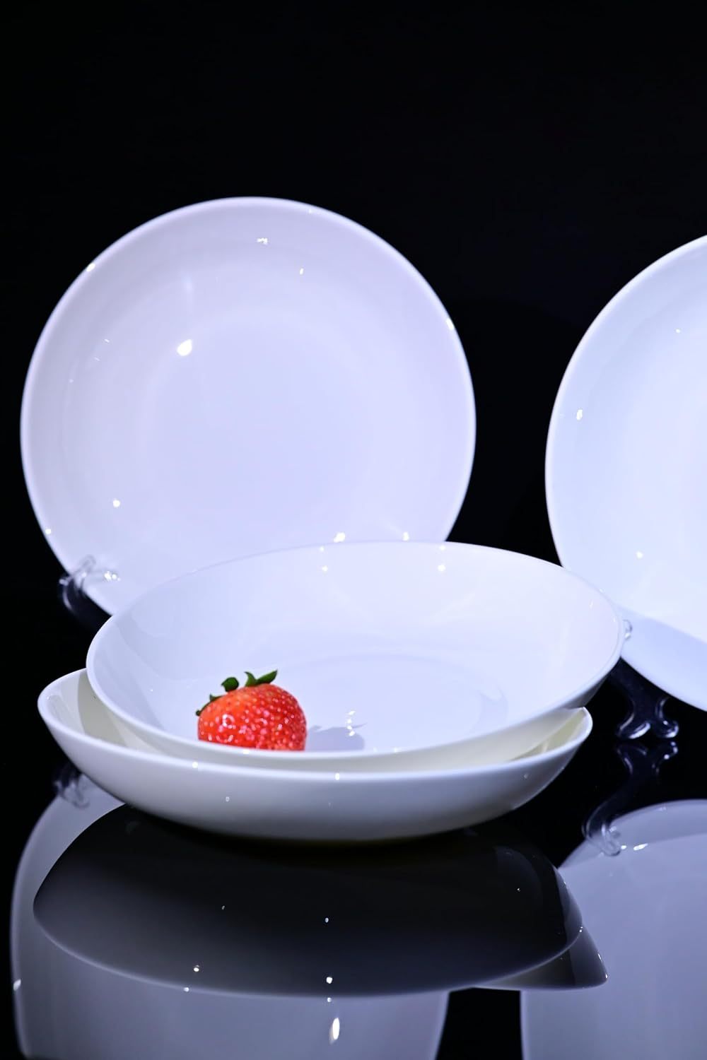 Shopi Vella bone china dinnerware set with white plates displayed and a single strawberry on one plate