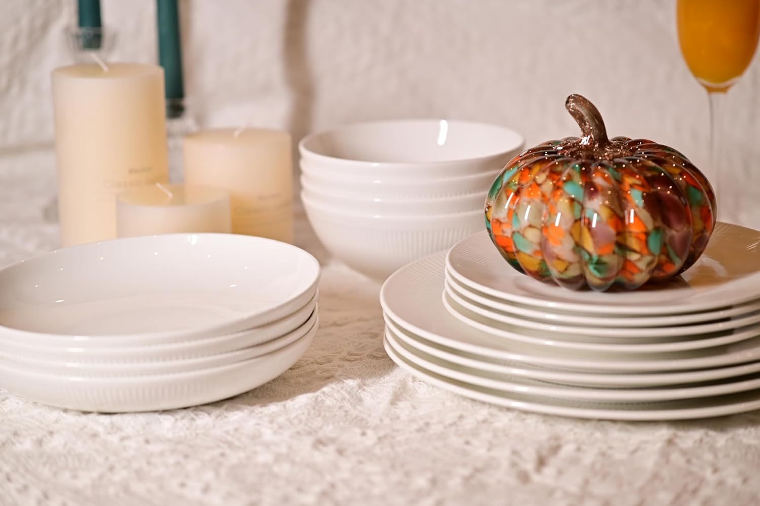 Shopi Vella bone china dinnerware set with white plates and bowls arranged on a textured surface