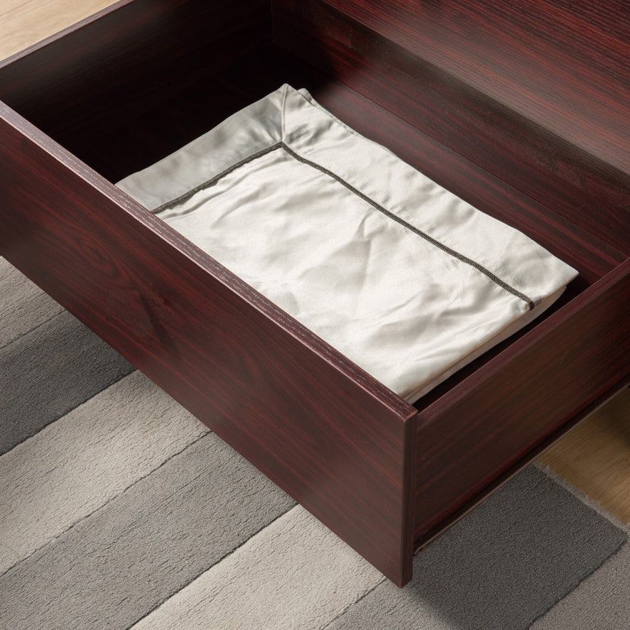 Shopi Vella wooden bedroom dresser drawer open with white folded cloth inside on striped rug