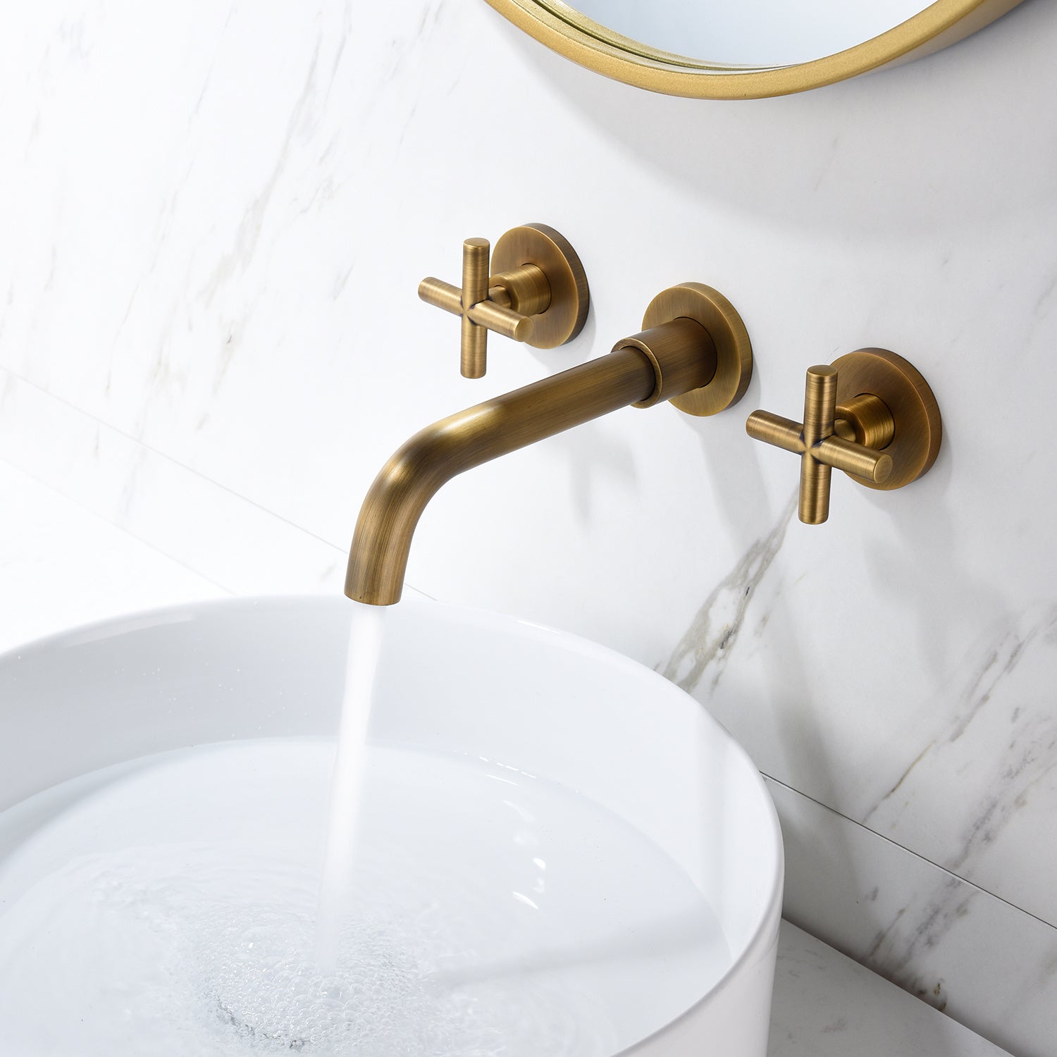Shopi Vella wall mounted bathroom faucet in brushed brass with cross handles and water running into white sink