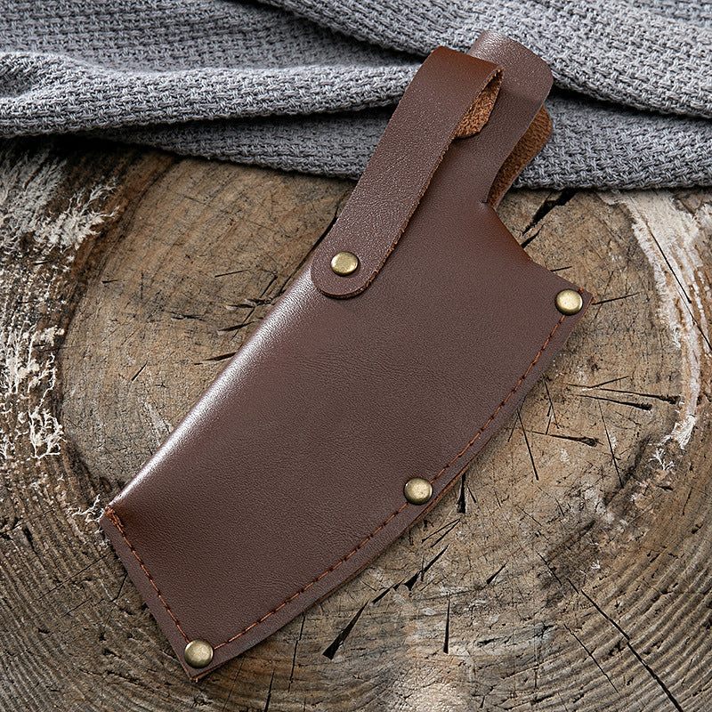 Brown leather sheath case for kitchen deboning knife on rustic wooden surface with gray cloth