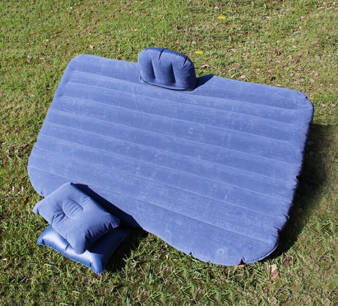 Blue car inflatable bed with two matching pillows on green grass outdoor