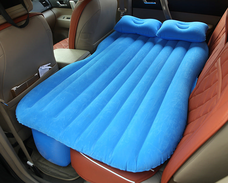 Blue car inflatable bed with pillows set up in backseat of a vehicle for comfortable travel rest