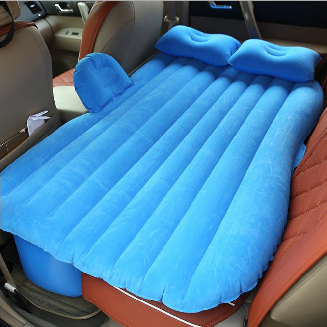 Blue car inflatable bed with pillows set up in the backseat of a vehicle for comfortable travel rest
