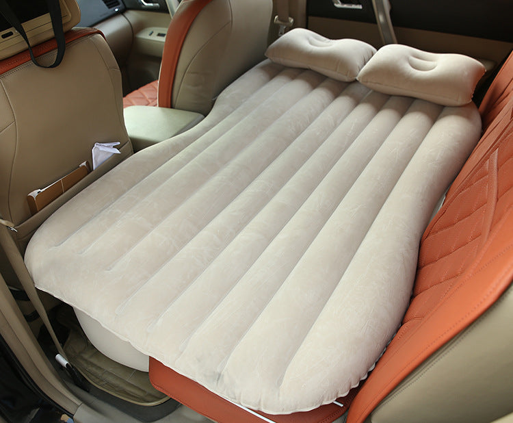 Beige car inflatable bed with two pillows set up on backseat for comfortable travel rest