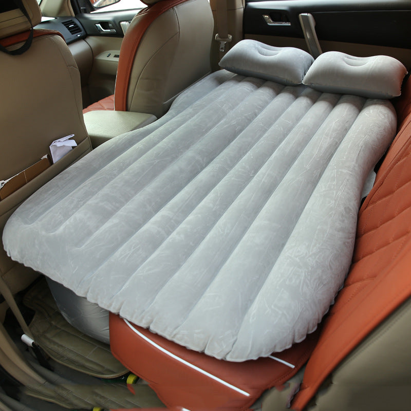 Gray car inflatable bed with two pillows set up on the backseat for comfortable travel rest