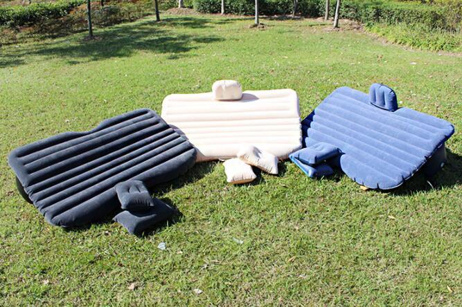 Three car inflatable beds in black, beige, and blue colors displayed outdoors on grass