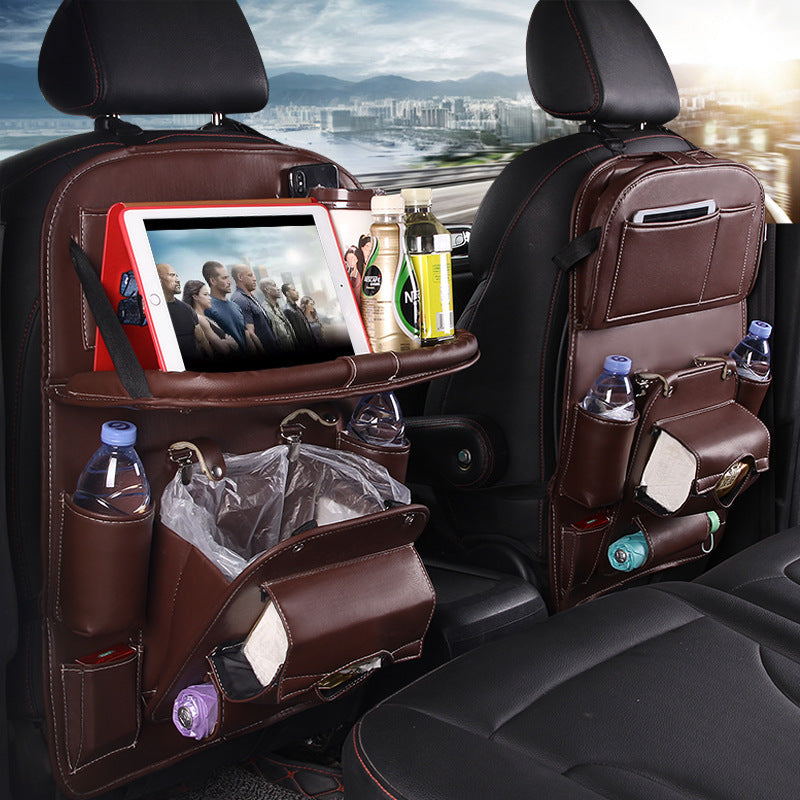 Shopi Vella brown leather car seat back storage bag with pockets holding tablet bottles and trash bag