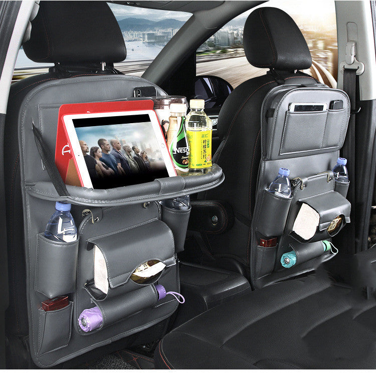 Shopi Vella car seat back storage bag in black with multiple compartments holding bottles, tablet, and tissues