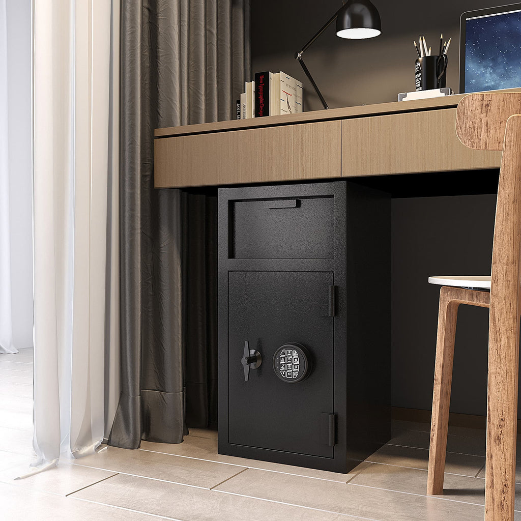 Black carbon steel digital safe box placed under a wooden desk in a modern home office