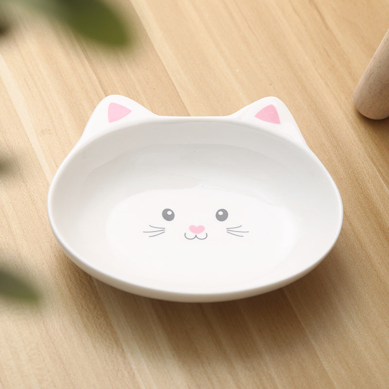 White ceramic cat face pet bowl with pink ears and cute whisker design on wooden surface