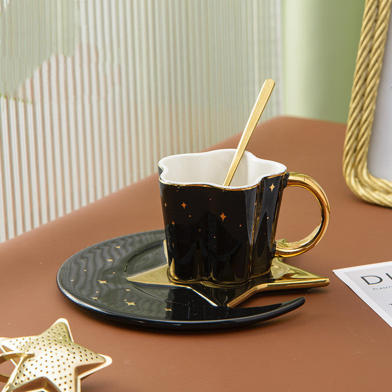 Shopi Vella ceramic cup with star and moon saucer in black and gold with matching gold spoon