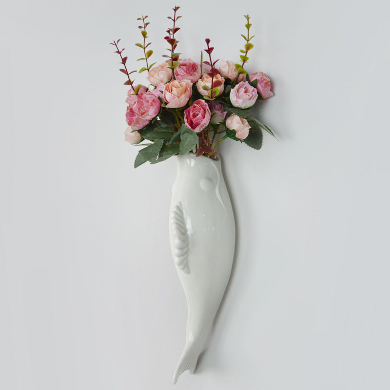 Ceramic goldfish wall vase holding pink and green artificial flowers for home storage decor
