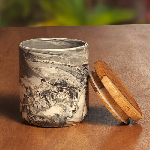 Marble-patterned ceramic jar with wooden lid on wooden surface for kitchen storage