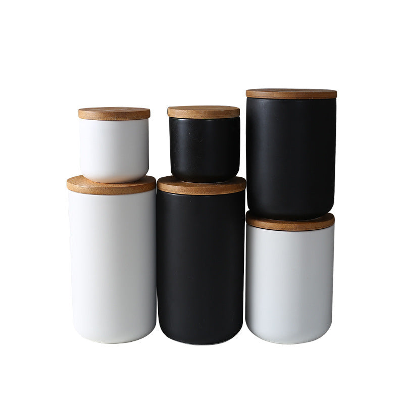 Set of black and white ceramic kitchen storage jar containers with wooden lids by Shopi Vella