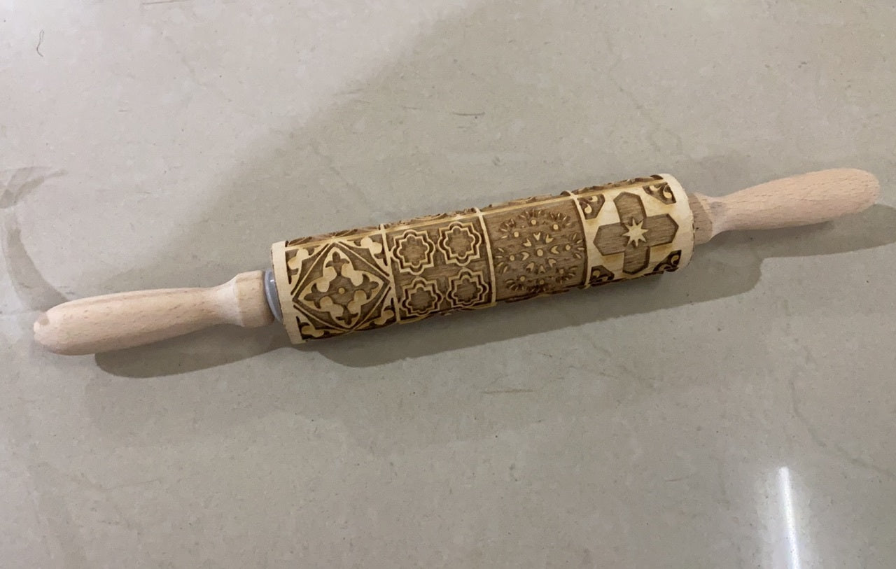 Shopi Vella Christmas embossing rolling pin with intricate holiday pattern carvings on wooden surface