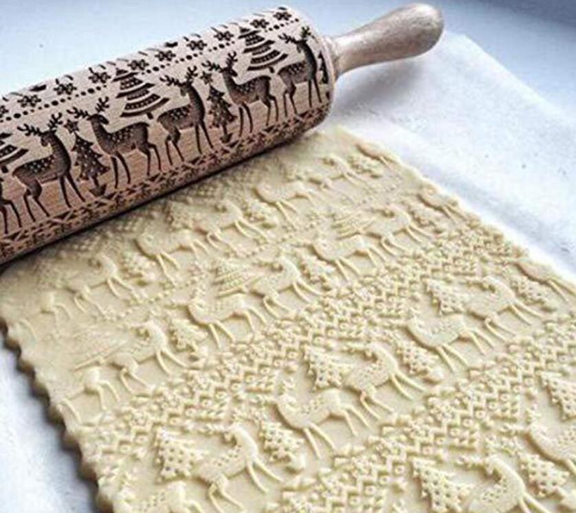 Shopi Vella Christmas embossing rolling pin creating reindeer and tree patterns on dough