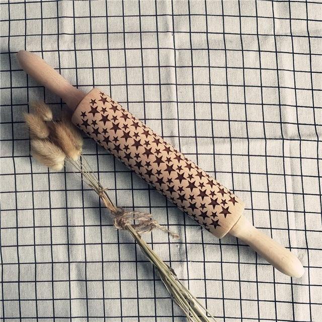 Shopi Vella Christmas embossing rolling pin with star pattern on wooden surface and dried flowers