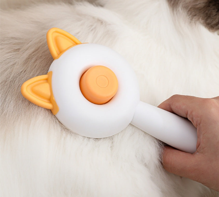 Shopi Vella self cleaning pet brush with orange cat ears being used on white furry pet